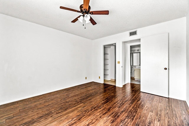 unfurnished bedroom featuring ensuite bathroom, hardwood / wood-style floors, ceiling fan, and a textured ceiling