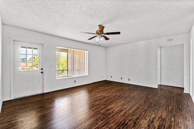 empty room with a textured ceiling, dark hardwood / wood-style flooring, and ceiling fan