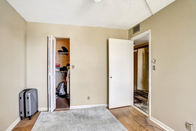 bedroom featuring a textured ceiling, a closet, and light wood-type flooring