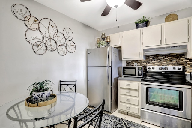 kitchen with light tile flooring, ceiling fan, appliances with stainless steel finishes, white cabinets, and backsplash