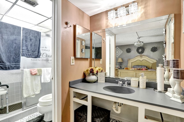 bathroom featuring tile flooring, oversized vanity, a shower with shower door, and toilet