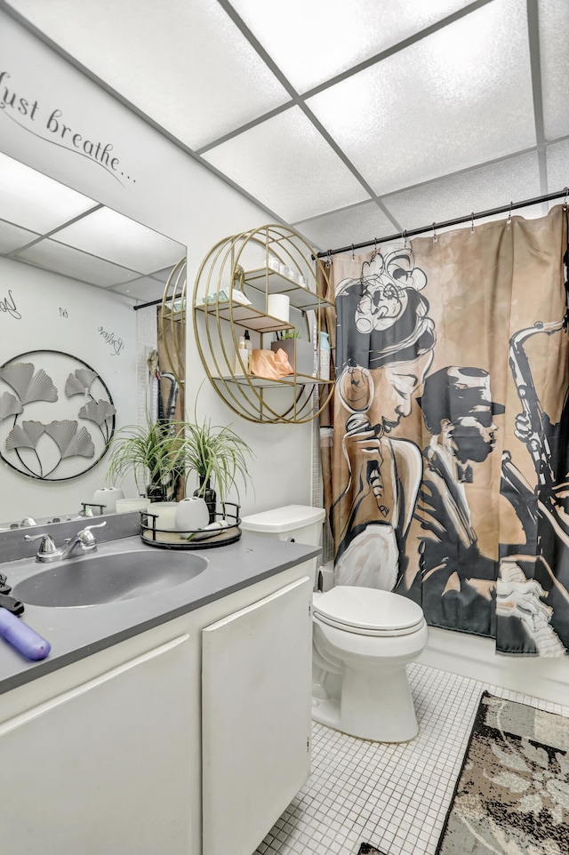 bathroom featuring a paneled ceiling, toilet, tile flooring, and large vanity