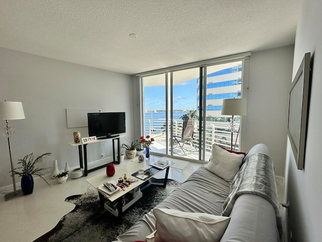 living room with a textured ceiling and floor to ceiling windows