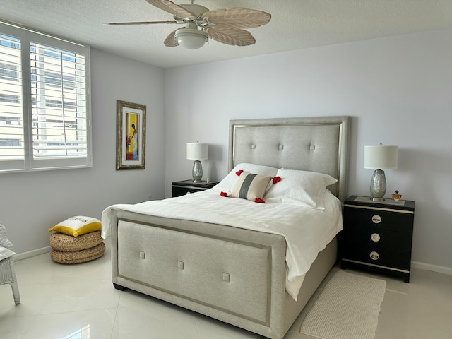 tiled bedroom with ceiling fan and a textured ceiling