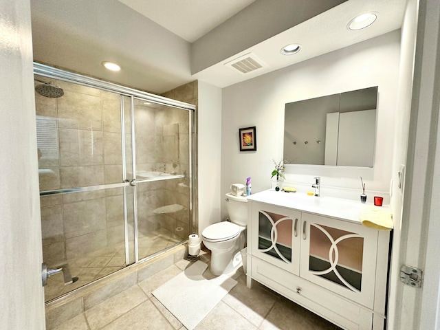 bathroom featuring tile patterned floors, vanity, toilet, and walk in shower