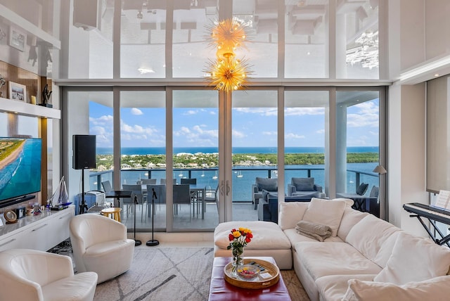 living room with a towering ceiling, a healthy amount of sunlight, and a water view