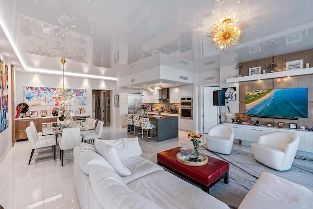 living room with a chandelier, a high ceiling, and light tile floors