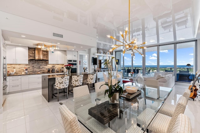 tiled dining room with an inviting chandelier and expansive windows