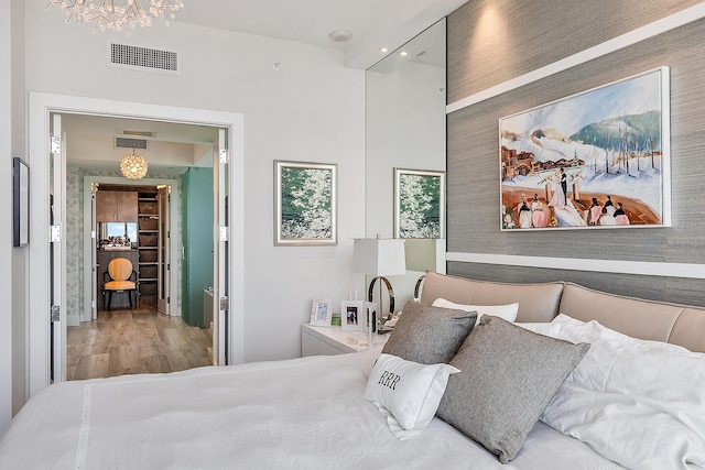 bedroom featuring a notable chandelier and light wood-type flooring