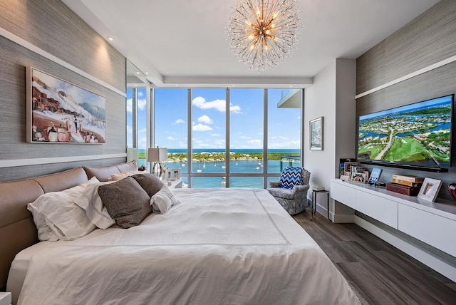 bedroom with expansive windows, access to exterior, a notable chandelier, a water view, and dark hardwood / wood-style flooring