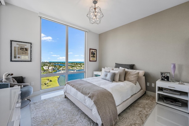 bedroom with light tile flooring, expansive windows, and a notable chandelier