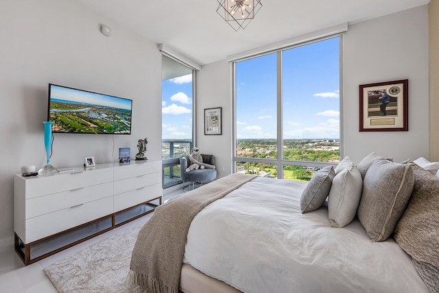 bedroom featuring a notable chandelier and floor to ceiling windows