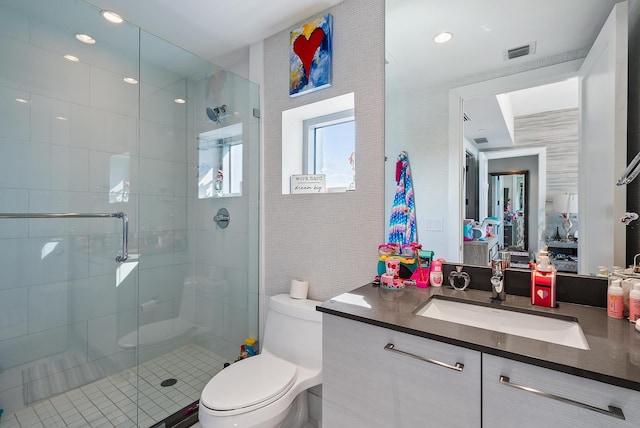 bathroom with toilet, a shower with shower door, and vanity