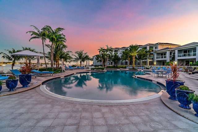 pool at dusk featuring a patio area