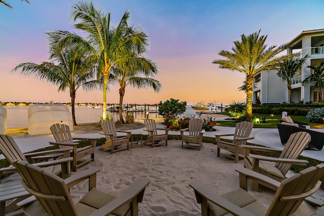 patio terrace at dusk featuring a water view