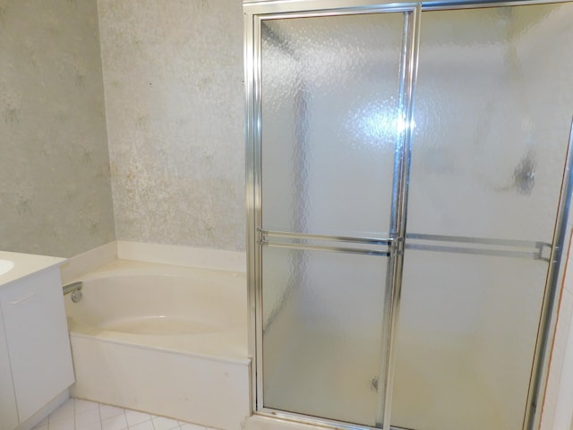 bathroom with vanity, shower with separate bathtub, and tile floors