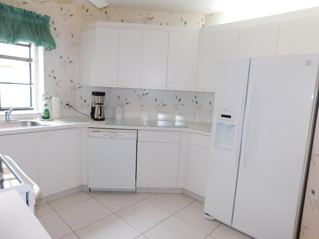 kitchen featuring light tile floors, white appliances, white cabinets, backsplash, and sink