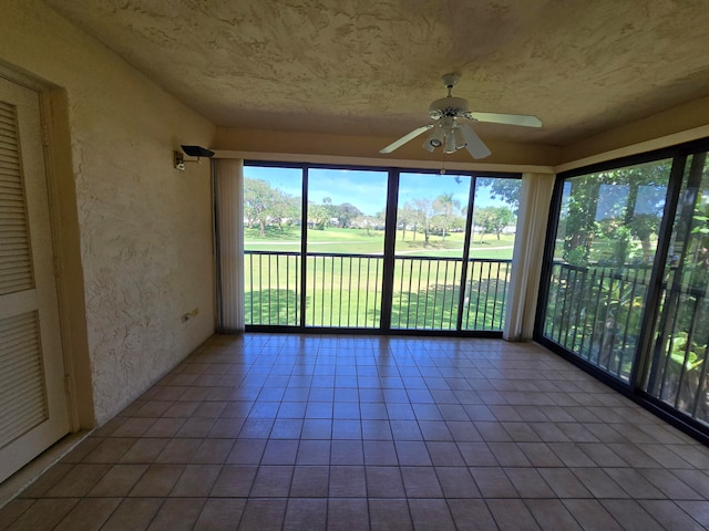 unfurnished sunroom featuring ceiling fan