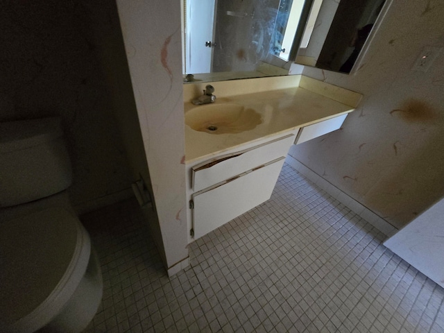 bathroom featuring tile floors, vanity with extensive cabinet space, and toilet