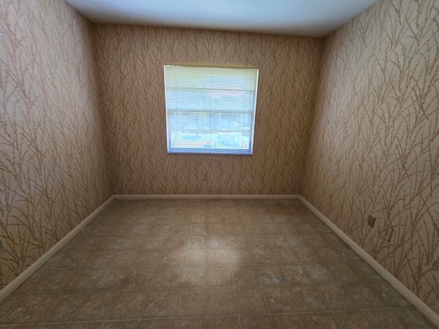 spare room with dark tile floors