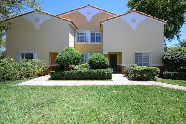 mediterranean / spanish-style house featuring a front yard