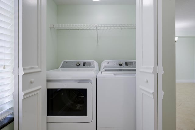 laundry area featuring independent washer and dryer and light tile floors