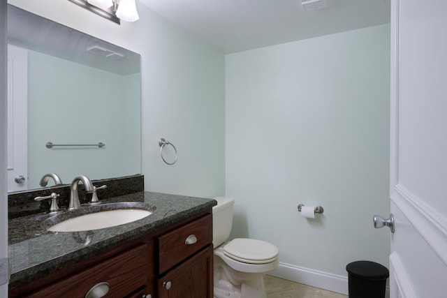 bathroom with vanity with extensive cabinet space, toilet, and tile flooring