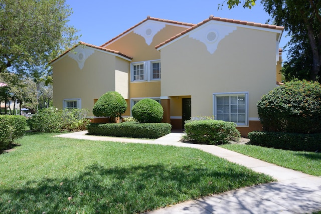 mediterranean / spanish-style home with a front lawn