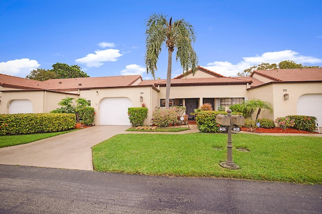 mediterranean / spanish home with a garage and a front lawn