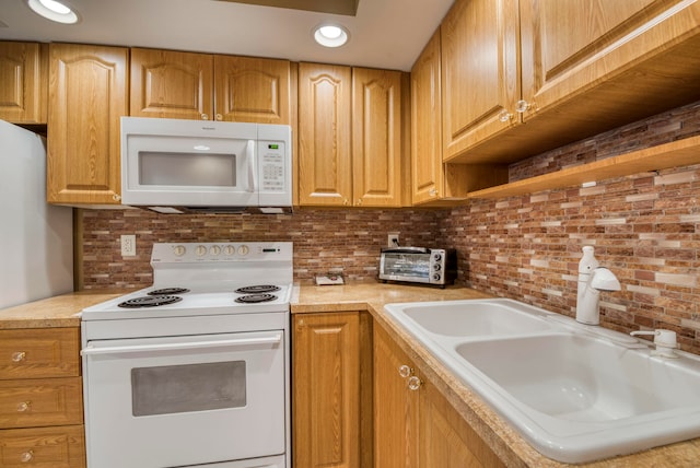 kitchen featuring white appliances and sink