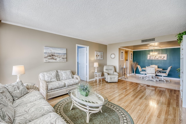336 Golfview Rd Unit 1011, North Palm Beach, FL 33408 - living area with a textured ceiling, wood finished floors, a chandelier, baseboards, and crown molding