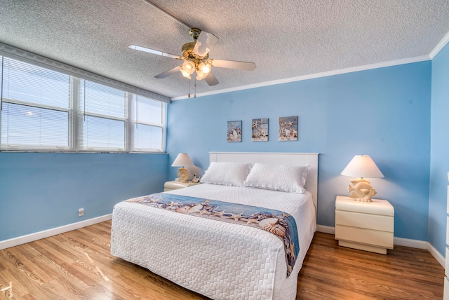 bedroom featuring a textured ceiling, crown molding, light hardwood / wood-style floors, and ceiling fan