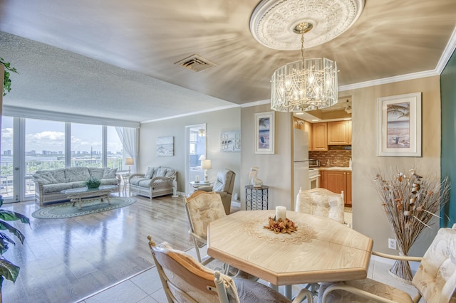 336 Golfview Rd Unit 1011, North Palm Beach, FL 33408 - dining room with a chandelier, a city view, baseboards, crown molding, and light wood finished floors