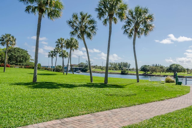 view of property's community featuring a yard, volleyball court, and a water view