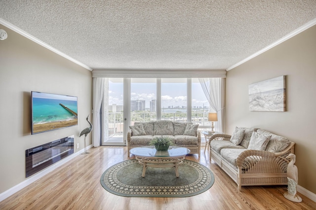 336 Golfview Rd Unit 1011, North Palm Beach, FL 33408 - living room featuring ornamental molding, a textured ceiling, wood finished floors, plenty of natural light, and baseboards