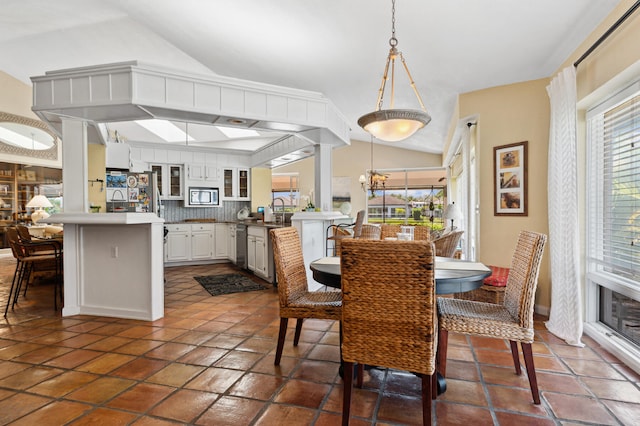 dining room featuring dark tile floors, an inviting chandelier, and a healthy amount of sunlight