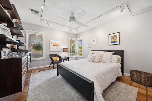 bedroom featuring ceiling fan, track lighting, and tile floors