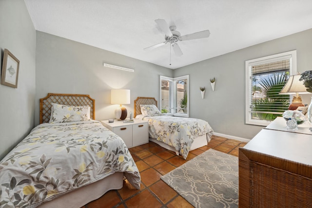 bedroom with dark tile floors and ceiling fan