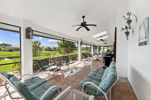 sunroom / solarium with a water view, ceiling fan, and a skylight