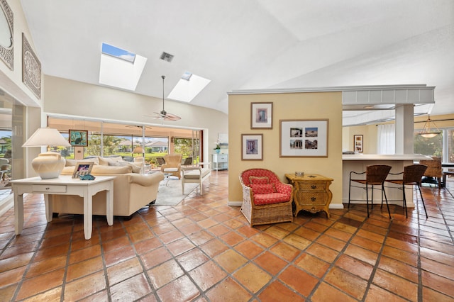 living room with vaulted ceiling with skylight, tile flooring, and ceiling fan