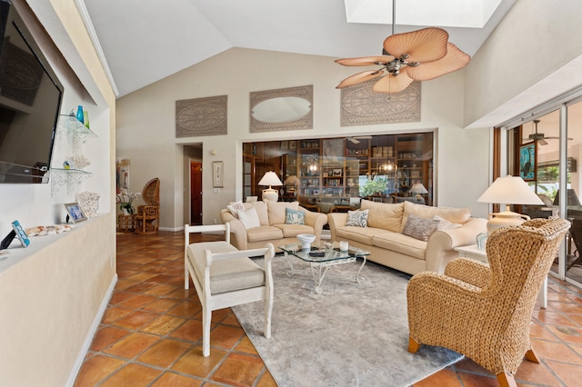 tiled living room with ceiling fan, high vaulted ceiling, and a skylight