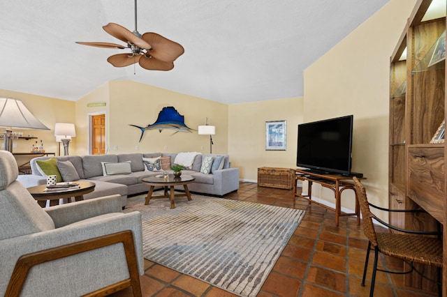 living room with dark tile floors, ceiling fan, and vaulted ceiling