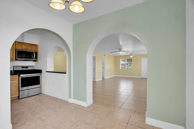 kitchen featuring ceiling fan, light tile floors, and stainless steel appliances