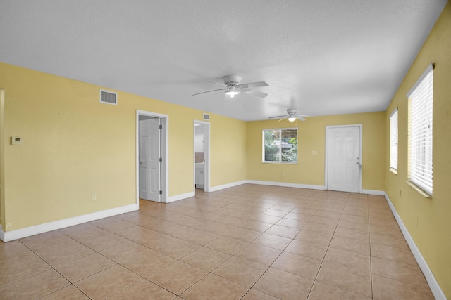 tiled spare room with ceiling fan and a textured ceiling