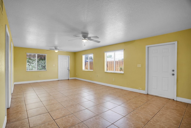 tiled spare room with ceiling fan and a textured ceiling