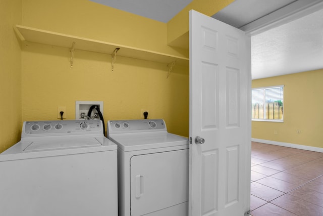 laundry area with light tile floors, hookup for a washing machine, and washing machine and clothes dryer