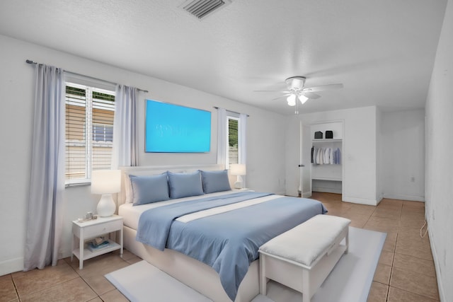 tiled bedroom featuring ceiling fan