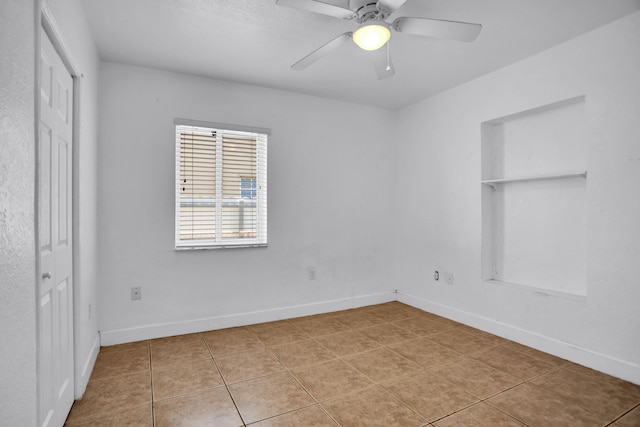 spare room with ceiling fan and tile floors