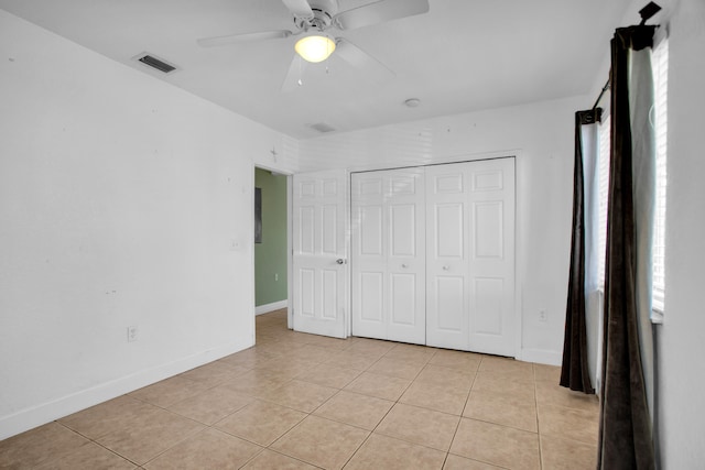 unfurnished bedroom with a closet, ceiling fan, and light tile floors