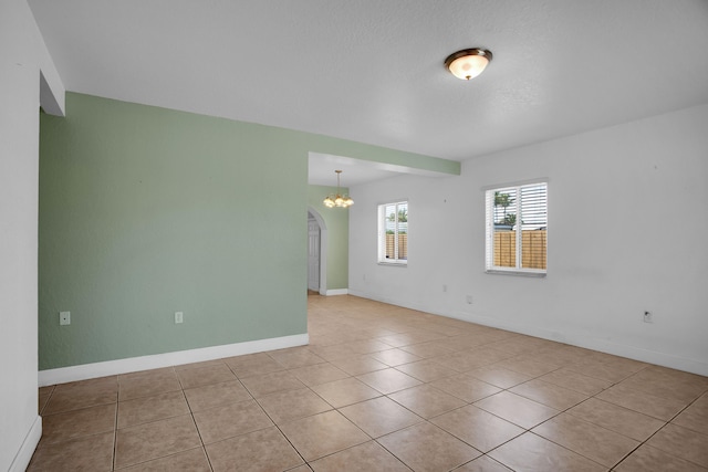 tiled empty room with a chandelier